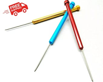 May include: Three metal tools with pointed tips. One is gold, one is blue, and one is red.