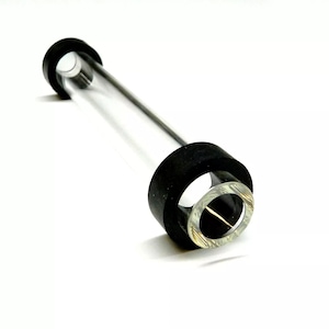 May include: A clear glass tube with black rubber rings at each end. The tube is approximately 25 cm long and has a diameter of about 2.5 cm.