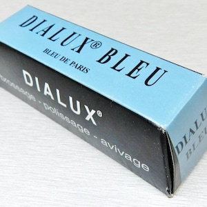 May include: A blue and black box with the text "Dialux Bleu" and "Bleu de Paris" on the front. The box also has the text "Dialux" and "broyage - polissage - avitage" on the side.