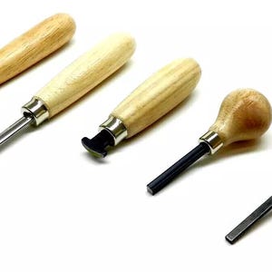 Könnte beinhalten: Satz mit fünf Holzgriff-Schnitzwerkzeugen mit verschiedenen Spitzenformen. Die Werkzeuge werden zum Schnitzen von Holz, Leder und anderen Materialien verwendet.