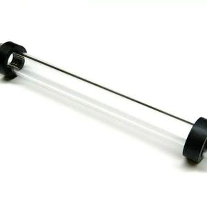 May include: A clear glass tube with black rubber end caps. The tube is approximately 30 cm long.