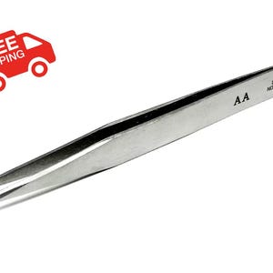 May include: A pair of silver stainless steel tweezers with a non-magnetic finish. The tweezers have a pointed tip and are labeled "AA" and "STAINLESS NON-MAGNETIC".