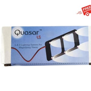 May include: A white box with the text "Quasar™ LS" and "LED Lighting System For Magnifying Visors" on it. The box shows a black and white image of a magnifying visor with LED lights.