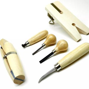 May include: A set of jewelry making tools including a ring mandrel, a wooden ring clamp, three wooden handled tools with metal tips, and a wooden ring sizing block.