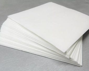 May include: A stack of white, square paper napkins. The napkins are neatly arranged, with the top ones slightly fanned out. The paper appears to be smooth and clean, suitable for various uses.