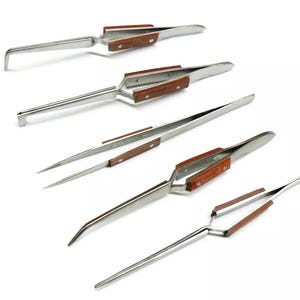 Puede incluir: Conjunto de cinco pinzas de acero inoxidable con mangos de madera. Las pinzas tienen diferentes formas y tamaños de puntas.