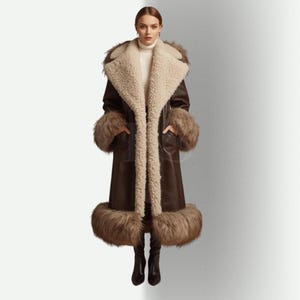 May include: A long, brown leather coat with a cream-colored shearling lining and trim. The coat features fur cuffs and a fur trim at the hem. The model is wearing black boots.