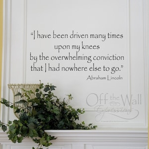 May include: A white wall with a black and white quote by Abraham Lincoln: "I have been driven many times upon my knees by the overwhelming conviction that I had nowhere else to go."