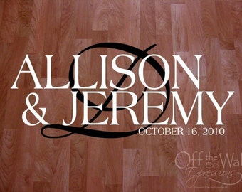 May include: White text on a wood background reads "Allison & Jeremy" with a black decorative flourish and the date "October 16, 2010". Below the date is the text "Off the Wall Expressions".