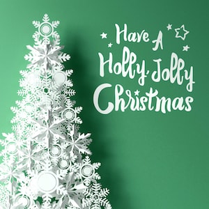 May include: White paper snowflake Christmas tree with the text "Have a Holly Jolly Christmas" on a green background.