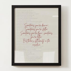 May include: A framed print with a white background and red text. The text reads "Sometimes you're driven, Sometimes you're stallin, Sometimes you're flyin', sometimes you're fallin, But there's still beauty in the negative."