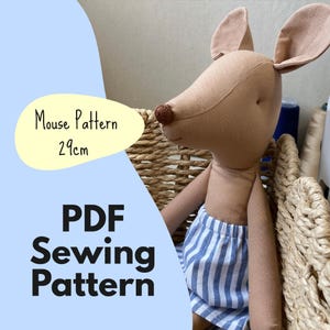 May include: A tan fabric mouse doll with large ears and a brown nose, wearing blue and white striped shorts. The image includes text that reads Mouse Pattern 29cm and PDF Sewing Pattern, indicating a digital template for a 29cm tall toy.