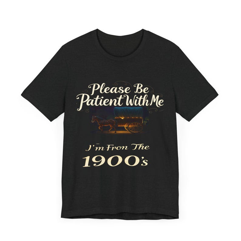 May include: Black t-shirt featuring a vintage-style design. The text reads, 'Please Be Patient With Me, I'm From The 1900's'.  A small illustration of a horse-drawn wagon is centered above the text. The shirt is a dark heather gray color and has a crew neck.