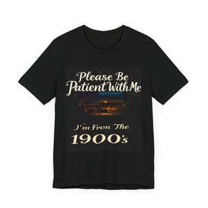 May include: Black t-shirt featuring a vintage-style design. The text on the shirt says, 'Please Be Patient With Me I'm From The 1900's.'  A picture of a horse-drawn wagon is displayed above the text. The text is cream-colored against a dark background. The shirt is a classic crew neck style.