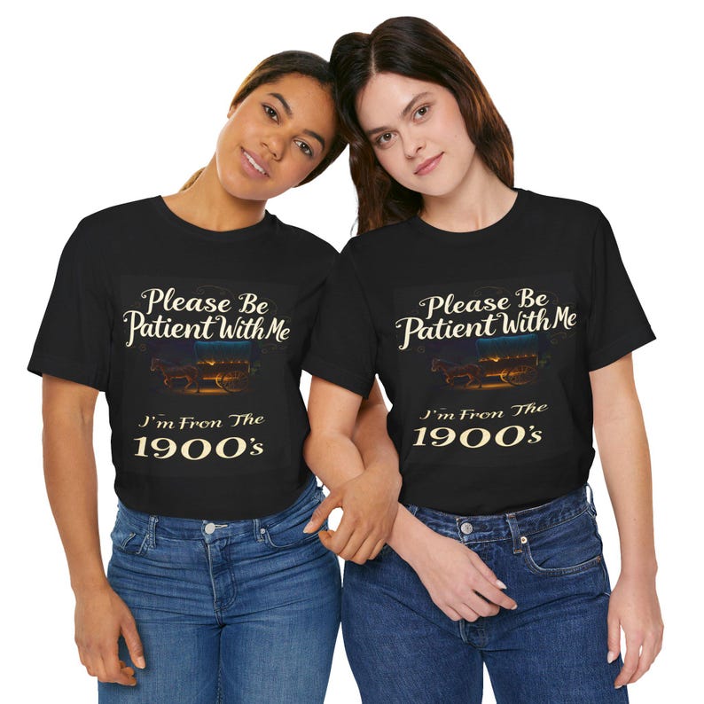 May include: Two black t-shirts with a vintage-style design. The shirts feature the text 'Please Be Patient With Me', 'I'm From The 1900's', and an image of a horse-drawn carriage.  The shirts are shown on two models. The design is in cream-colored text on a black background.