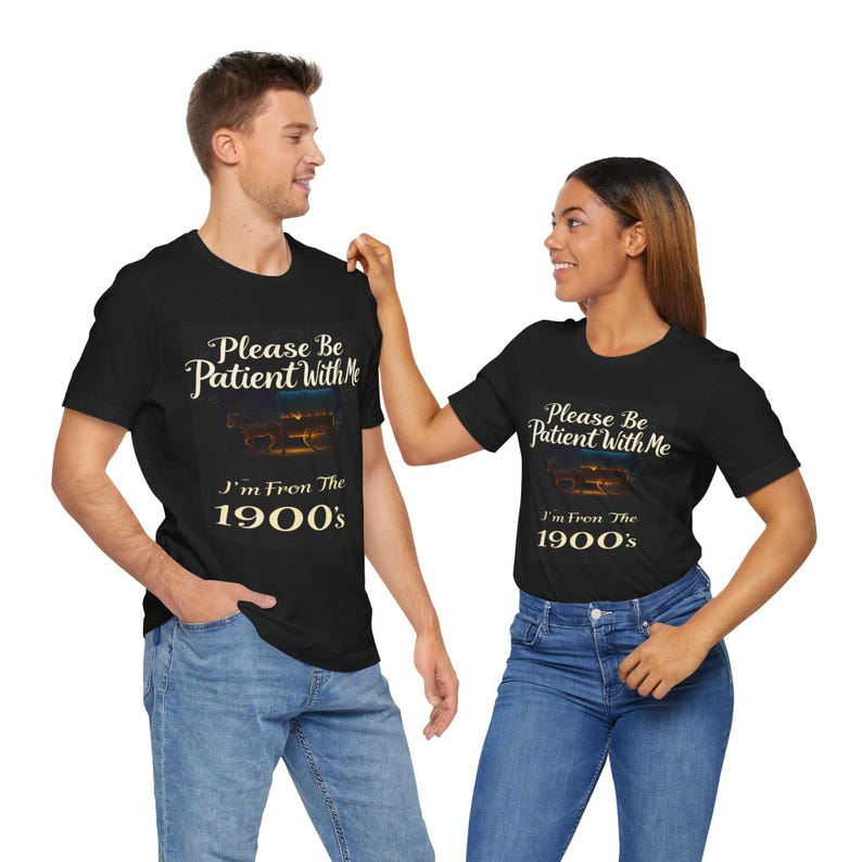 May include: Matching black t-shirts with a vintage-style design. The text on the shirts reads: 'Please Be Patient With Me, I'm From The 1900's.'  The shirts feature a nostalgic image of a horse-drawn carriage.  The design is printed in cream-colored text on a black background.