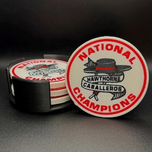 May include: Set of four white coasters with a red border and black text. The text reads "National Champions Hawthorne Caballeros" and features a black and white illustration of a hat with a red band.