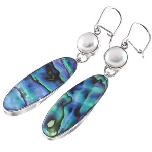 May include: A pair of silver earrings with a pearlescent, oval-shaped abalone shell design in shades of blue and green. Each earring features a white pearl and a silver hook.