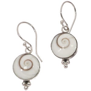 May include: A pair of silver earrings featuring a white, circular design with a brown spiral pattern. The earrings have a small cluster of silver beads at the bottom and a hook for the ear.