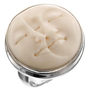 May include: A silver ring featuring a white carved moon face cameo. The moon face is detailed with eyes, nose, and mouth.
