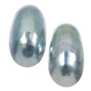 May include: Two lustrous, oval-shaped pearls with a silvery-blue iridescence. The pearls have a smooth surface and reflect light, creating a shimmering effect. The pearls are set against a white background.