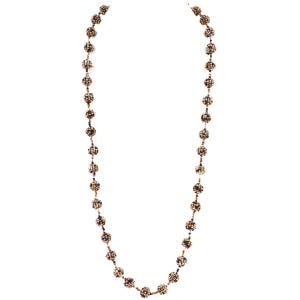 May include: A long beaded necklace with multiple spherical beads in shades of brown, gold, and black. The beads are evenly spaced along the length of the necklace, creating a textured accessory. The necklace is shown against a white background.