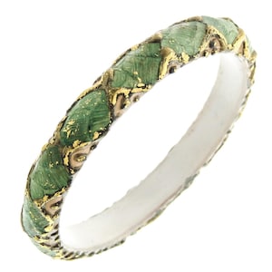 May include: A gold and green ring with a decorative design. The ring is made of metal and has a smooth, polished finish.