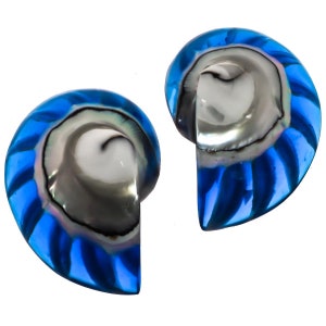 Può includere: Un paio di orecchini a forma di conchiglia blu e bianca. Gli orecchini sono realizzati in resina blu con un'intarsio di conchiglia bianca. L'intarsio di conchiglia ha un motivo a spirale.