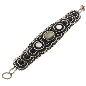 May include: A black beaded bracelet with silver accents and three round, iridescent stones. The stones are green, white, and white with a hint of green.