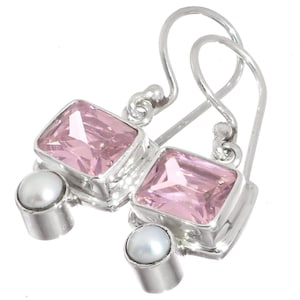 May include: A pair of silver earrings featuring rectangular pink gemstones and small white pearls. The earrings have a hook design for pierced ears. The gemstones are set in a silver bezel setting.