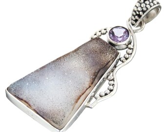 Puede incluir: Pendiente de plata con una piedra de ágata gris claro y marrón con un acento de piedra de amatista púrpura. El pendiente tiene un diseño de plata detallado.