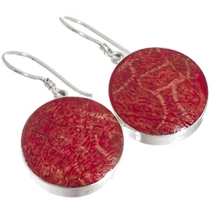 May include: A pair of silver dangle earrings with round red coral stones. The coral has a natural, textured pattern.