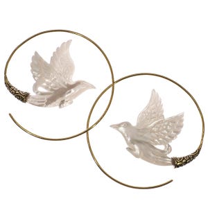 May include: A pair of earrings with a white dove design set within a gold-coloured spiral. The doves have outstretched wings, and the spiral ends have ornate detailing. The earrings are set against a white background.