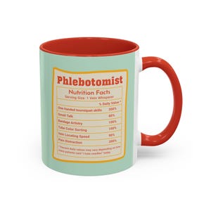 May include: A white ceramic mug with a red interior and handle. The mug features a light green exterior with a nutrition facts label for a phlebotomist, including humorous daily values for skills like "Small Talk" and "Pain Distraction."