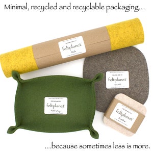 May include: A set of felt items, including a tray, coasters, and a roll of felt, all packaged in a simple brown paper tube. The felt items are in various shades of green, brown, and yellow. The packaging is labeled "feltplanet".