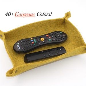 May include: A yellow felt remote control holder with two remotes inside. The text "40+ Gorgeous Colors!" is visible above the holder.