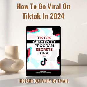 Könnte beinhalten: Ein digitales Tablet zeigt das Cover eines E-Books mit einem farbenfrohen, abstrakten Design. Das Cover zeigt den Text "TikTok Creativity Program Secrets" und "E-book Step by Step 2024". Das E-Book wurde von Elliot Sebastian Greyson erstellt. Der Text "Sofortige Lieferung per E-Mail" wird unter dem Tablet angezeigt.