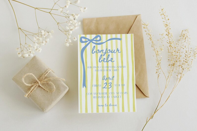 May include: A yellow and white striped baby shower invitation with a blue ribbon and bow. The text reads "bonjour bebe" and includes the date "April 23".