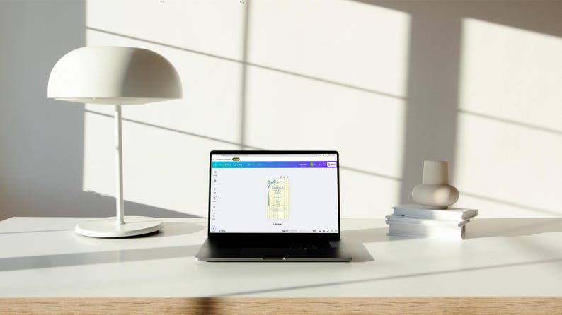 May include: A laptop computer with a white background is open to a design program. The screen shows a yellow and white design with a blue ribbon. The design is for a gift tag.