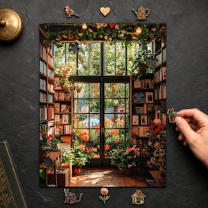 Peut inclure: Un puzzle rectangulaire représentant une bibliothèque ensoleillée avec des étagères du sol au plafond, une grande porte vitrée et des fleurs orange vives. Le puzzle inclut de petites pièces en bois en forme d'oiseau, cœur, théière, chat, fleur et maison.