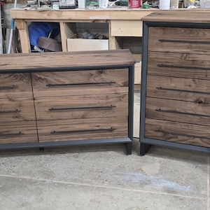 Op de afbeelding: Een set van vier houten dressoirs met zwarte metalen accenten. De dressoirs hebben meerdere lades en zijn in een rij gerangschikt. De dressoirs zijn gemaakt van donker hout met een natuurlijke nerf.