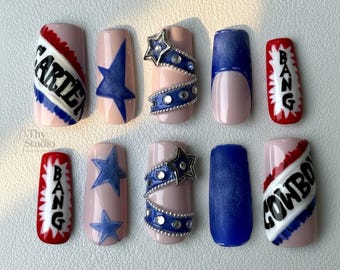 Puede incluir: Un conjunto de diez uñas artificiales con base rosa, con varios diseños. Algunas uñas tienen estrellas azules, mientras que otras muestran las palabras "CARTER", "BANG" y "COWBOY". Algunas uñas tienen adornos de estrellas azules y plateadas.