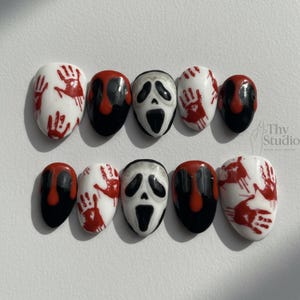 May include: A set of ten oval-shaped press-on nails with a Halloween theme. Designs include white nails with red handprints, black nails with red drips, and nails featuring a Scream mask.