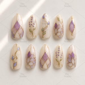 Può includere: Un set di dieci unghie finte con una base beige chiaro. Ogni unghia presenta un design unico, tra cui rametti di lavanda, motivi geometrici e motivi floreali in viola, verde e oro. Le unghie sono di forma ovale e hanno una finitura lucida.