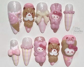 May include: A set of ten artificial nails with various designs. The nails feature pink, white, and brown colors, with decorative elements like bows, stars, and cartoon characters. Some nails are shaped like ice cream cones.