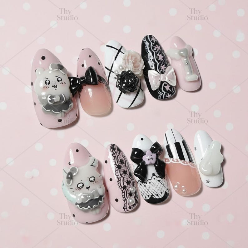 May include: A collection of decorated artificial nails in various designs. The nails feature pink, white, and black colors, with embellishments like bows, flowers, and cartoon characters. Some nails have lace patterns and piano key designs.
