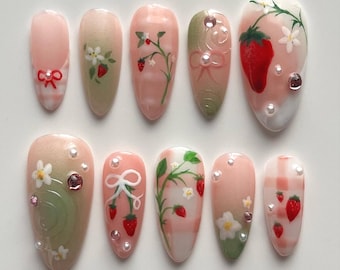 Presse de jardin de fraises peinte à la main sur des ongles, art d'ongle de pique-nique d'été