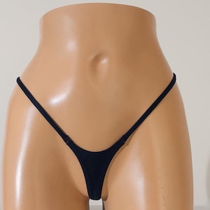 May include: Black micro thong underwear with thin straps. The underwear is on a mannequin.