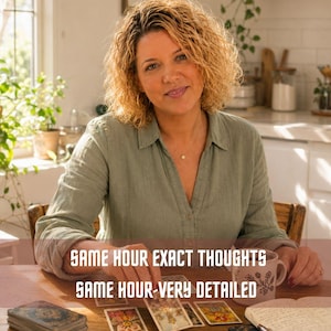 Könnte beinhalten: Eine Person in einem salbeigrünen Hemd sitzt an einem Holztisch mit Tarotkarten, einer Keramiktasse und einem Notizbuch. Der Text auf dem Bild lautet: SAME HOUR EXACT THOUGHTS SAME HOUR-VERY DETAILED. Die Karten zeigen farbenfrohe Illustrationen.