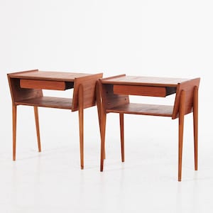 May include: A pair of matching wooden nightstands featuring a warm brown finish, each constructed with a single horizontal drawer positioned beneath a flat top surface, an open storage shelf below the drawer, and four tapered legs.